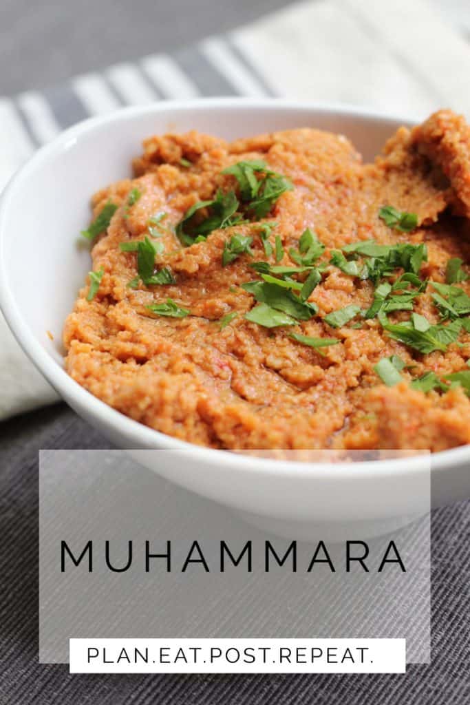 A white bowl of a bright red dip at the top and the word, "Muhammara" at the bottom. 