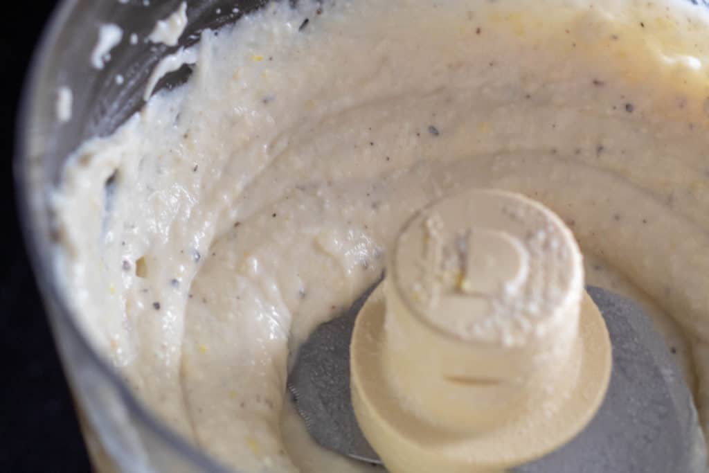 Lemon ricotta sauce blended in the bowl of a food processor.