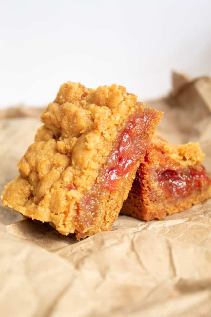 Peanut Butter and Jelly Bars on a crumpled paper bag surface.