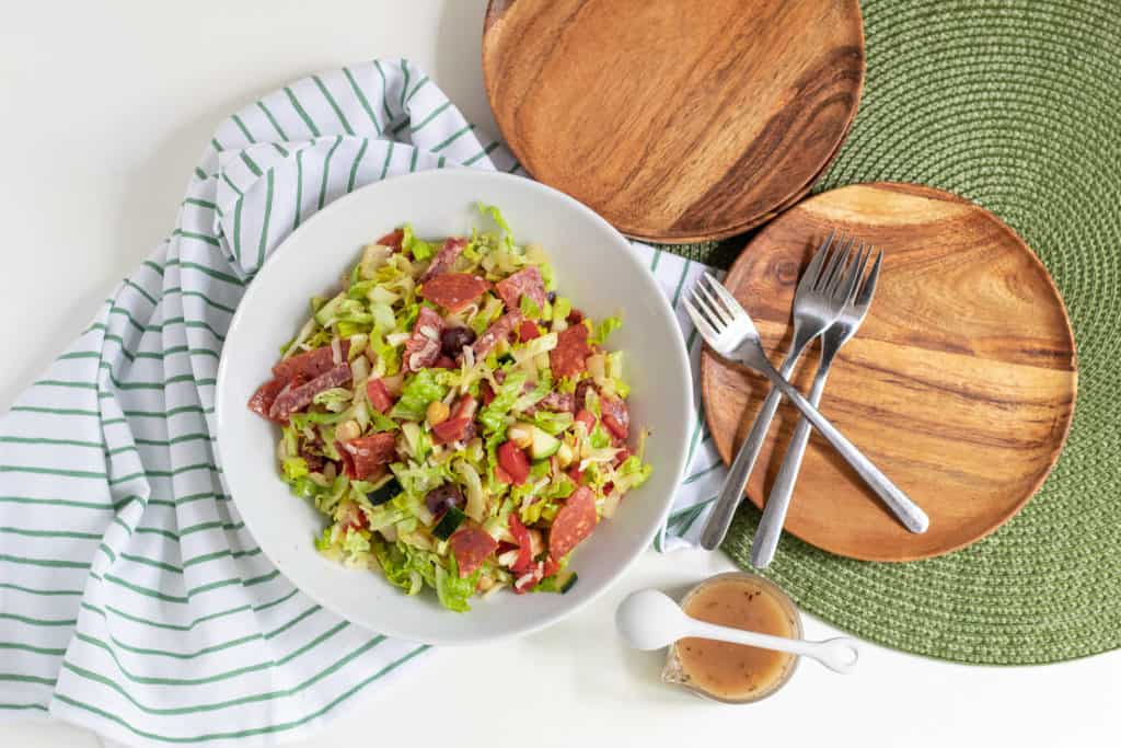 An overhead shot of Antipasto Chopped Salad on a white and green background.