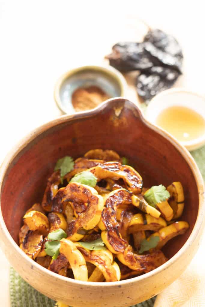 A brown bowl of Roasted Delicata with Honey Ancho Vinaigrette