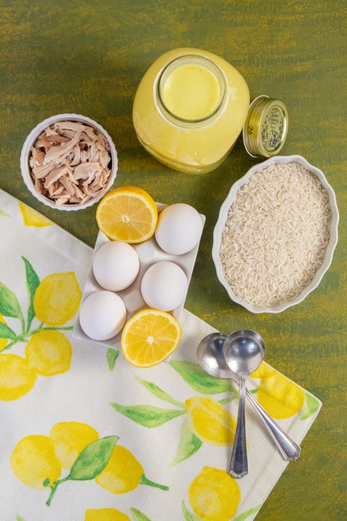 Ingredients for Avgolemono Soup are arranged over a green and yellow background