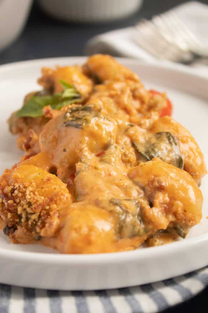 Baked Gnocchi with Sun Dried Tomato Cream is pictured up close on a white plate.