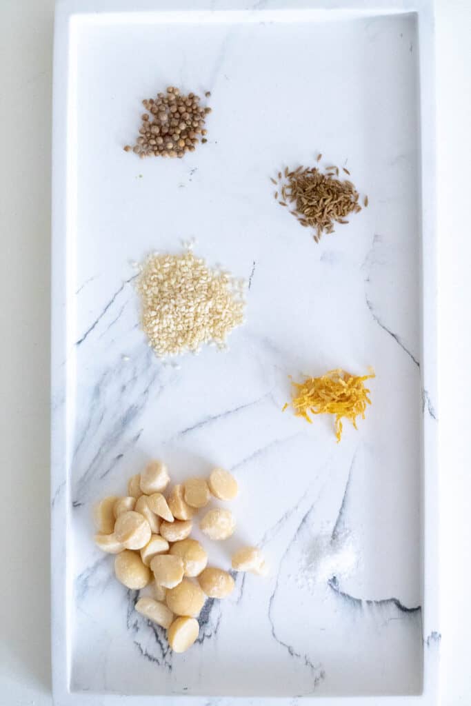 Ingredients for Homemade Macadamia Dukkah are arranged on a marble tray.