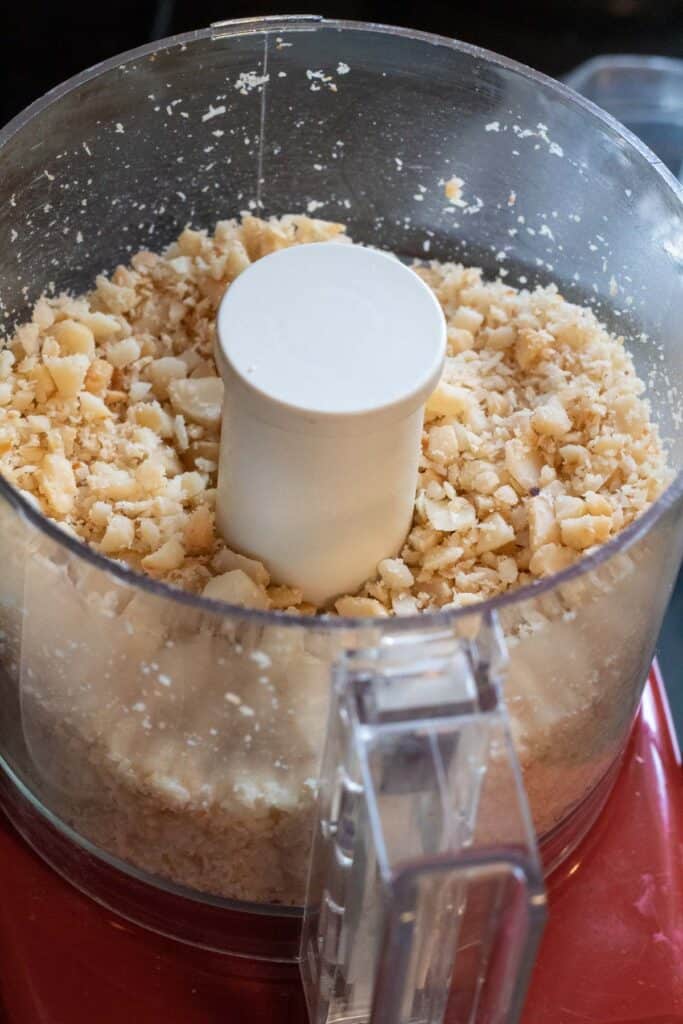 Roasted macadamia nuts chopped in a food processor.