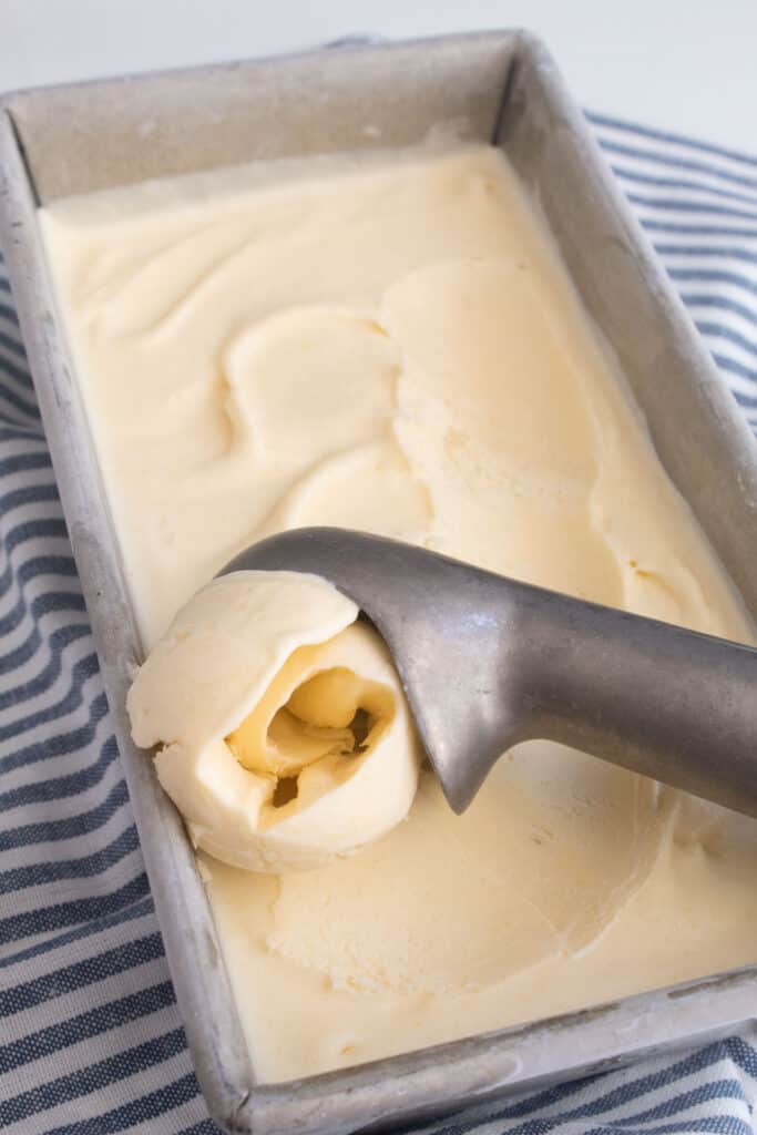 Pale yellow ice cream scooped out of a loaf pan.