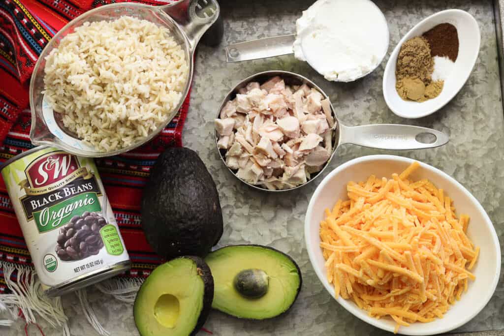 Ingredients fo Freezer Friendly Chicken Avocado Burritos (baked or grilled) are arranged on a silver tray.