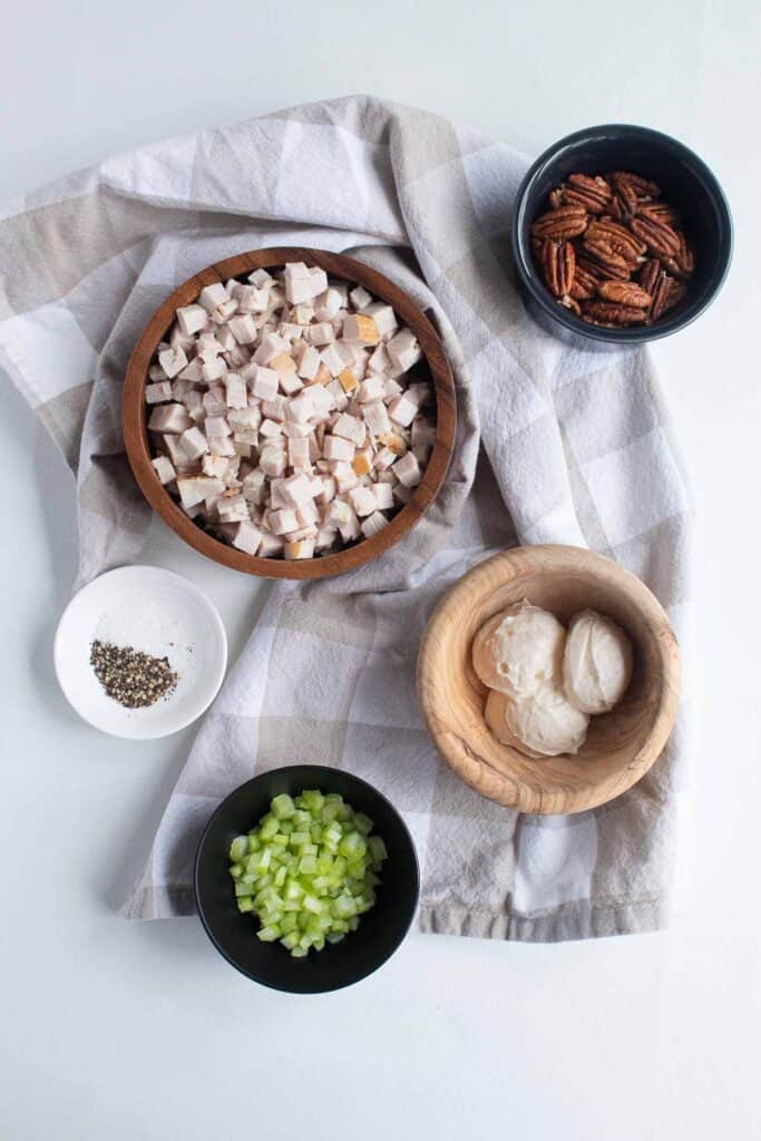 Ingredients for Easy Chicken Pecan Salad arranged on a checkered cloth.