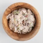Easy Chicken Pecan Salad piled in a wooden bowl with chunks of pecans and celery.