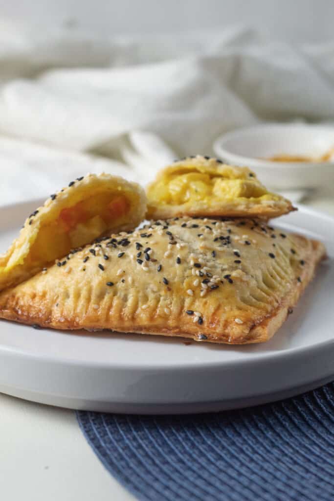 A closeup of teh texture of a baked turnover and the yellow curry filling.