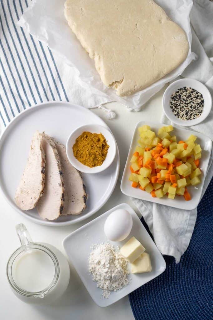 Ingredients for Leftover Turkey Turnovers with Simple Potato Curry Filling arranged on a blue and white surface.