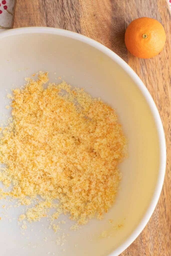 Granulated sugar rubbed with orange zest to make a pale orange colored sugar.