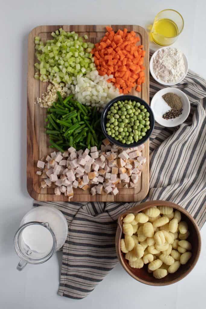Ingredients for Veggie Packed Chicken Gnocchi Soup for Instant Pot or Stovetop are displayed on a white surface.