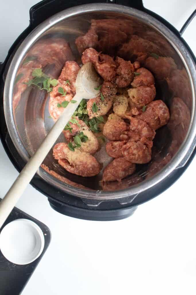 The fresh sausage, seasonings, and oregano in the bottom if an instant pot insert at the beginning of cooking.