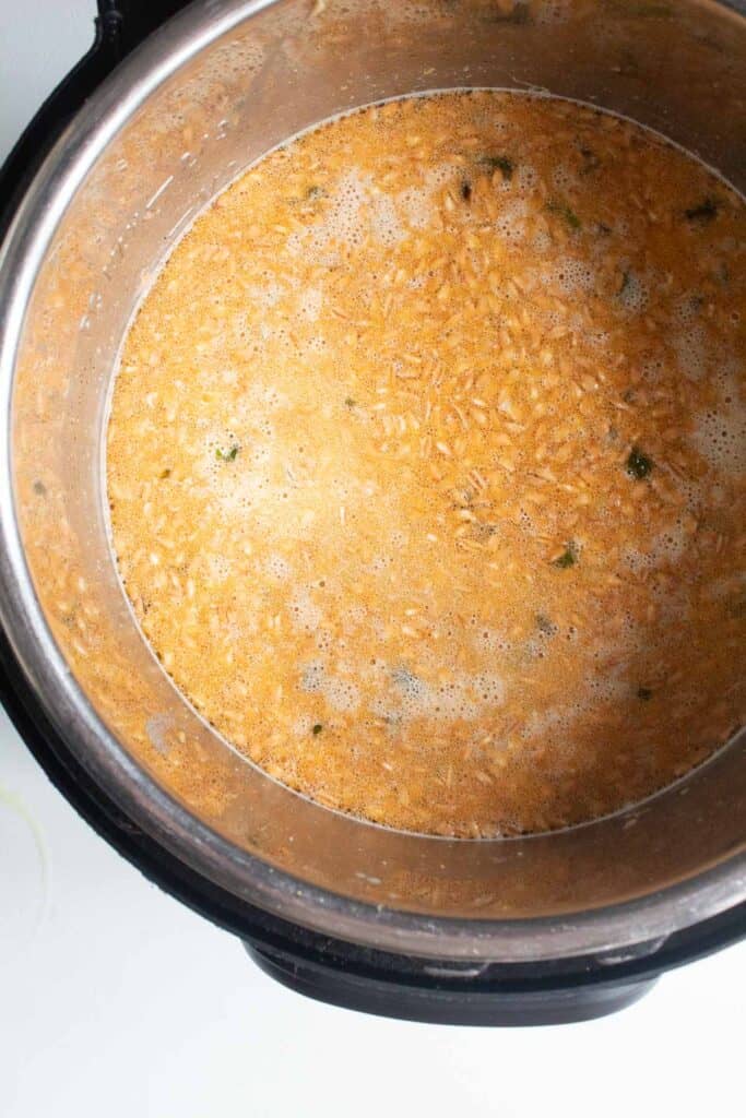 The soup before cooking in the pressure cooker, with farro and broth visible.