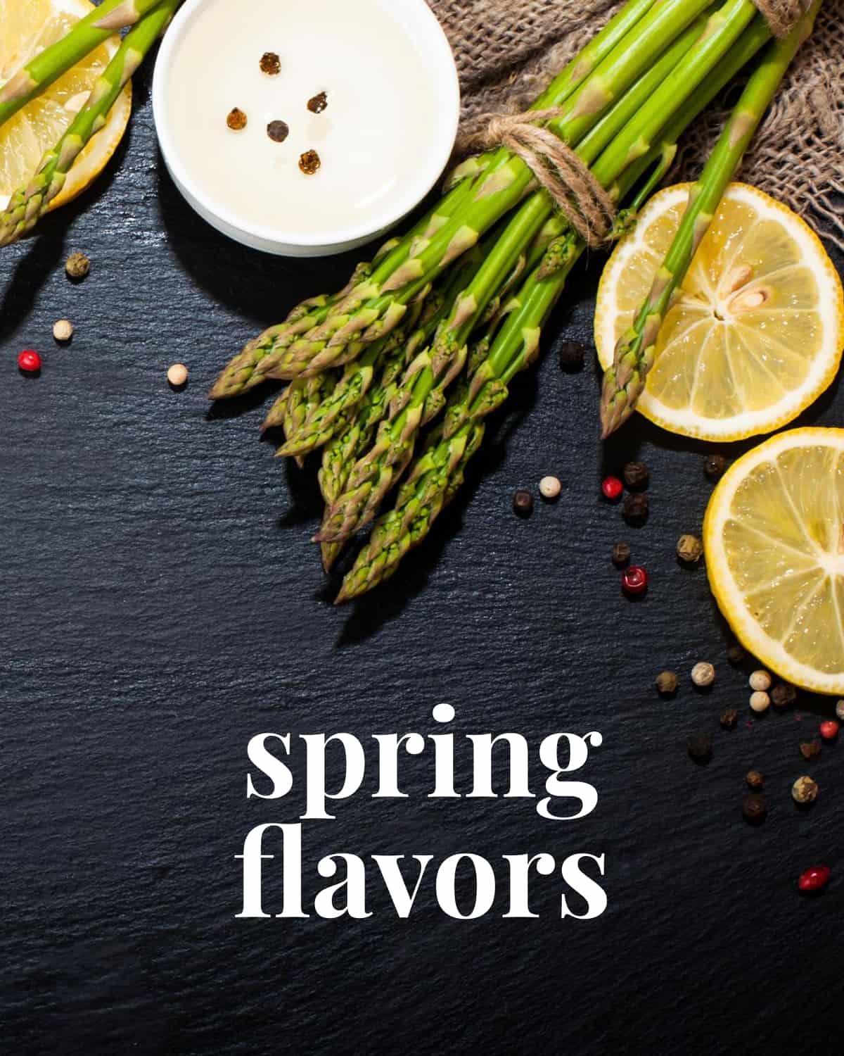 Lemons and asparagus on a black background with the words "spring flavors" at the bottom.