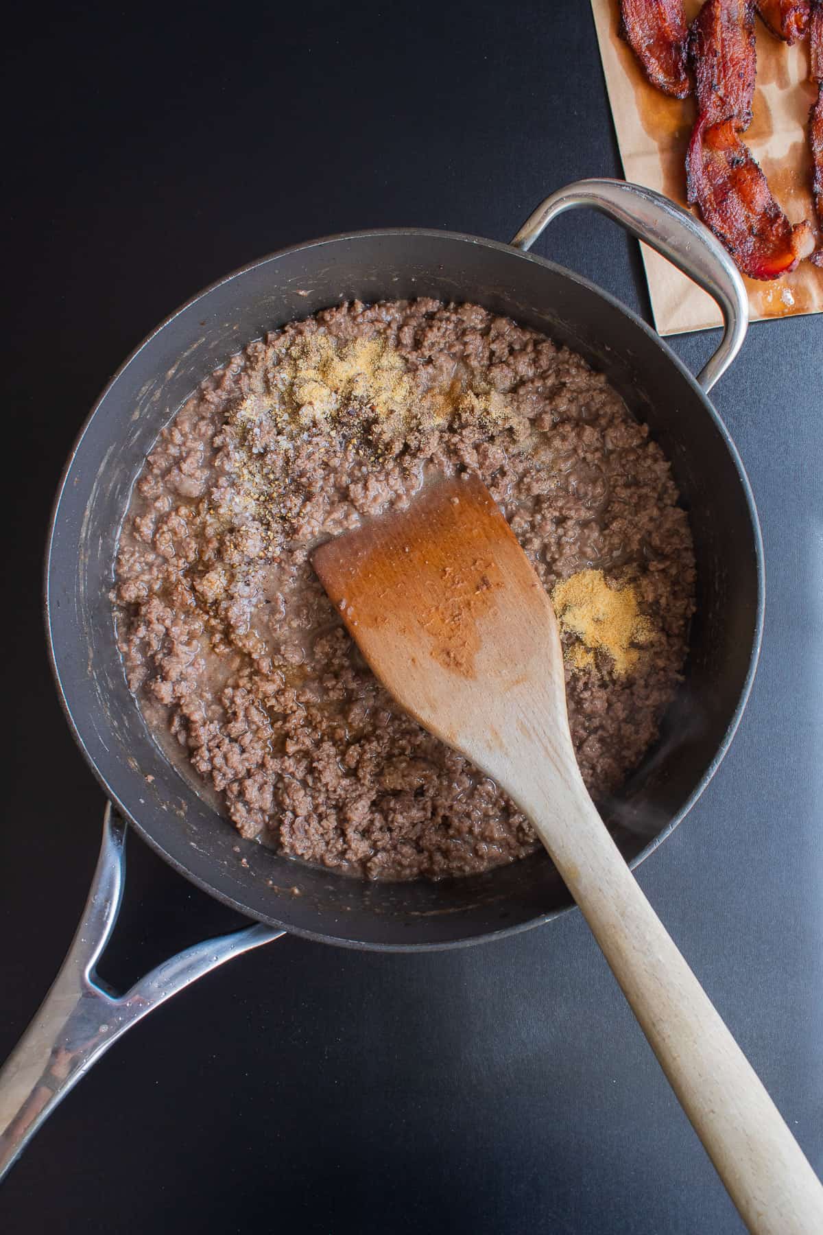 Spices and seasonings added to the browned ground beef in a skillet.