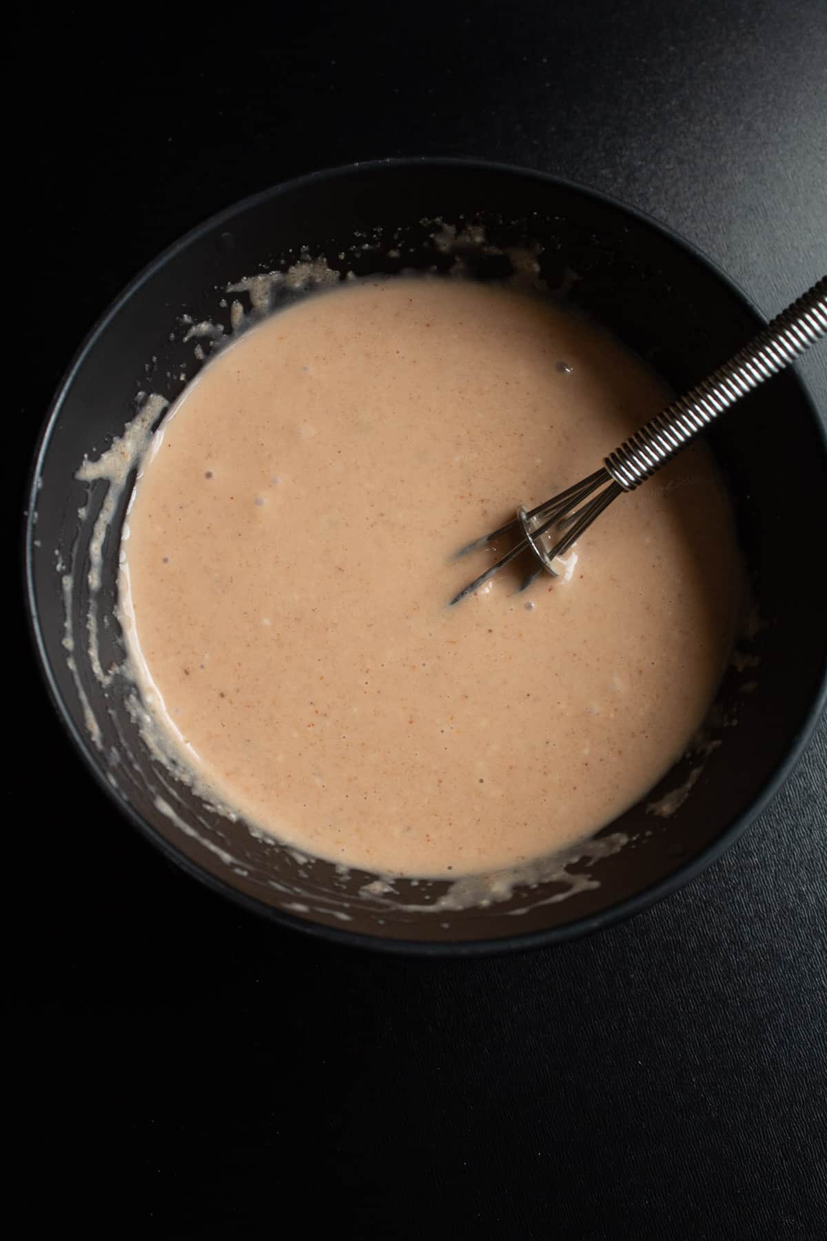 The special sauce whisked together in a small black bowl.