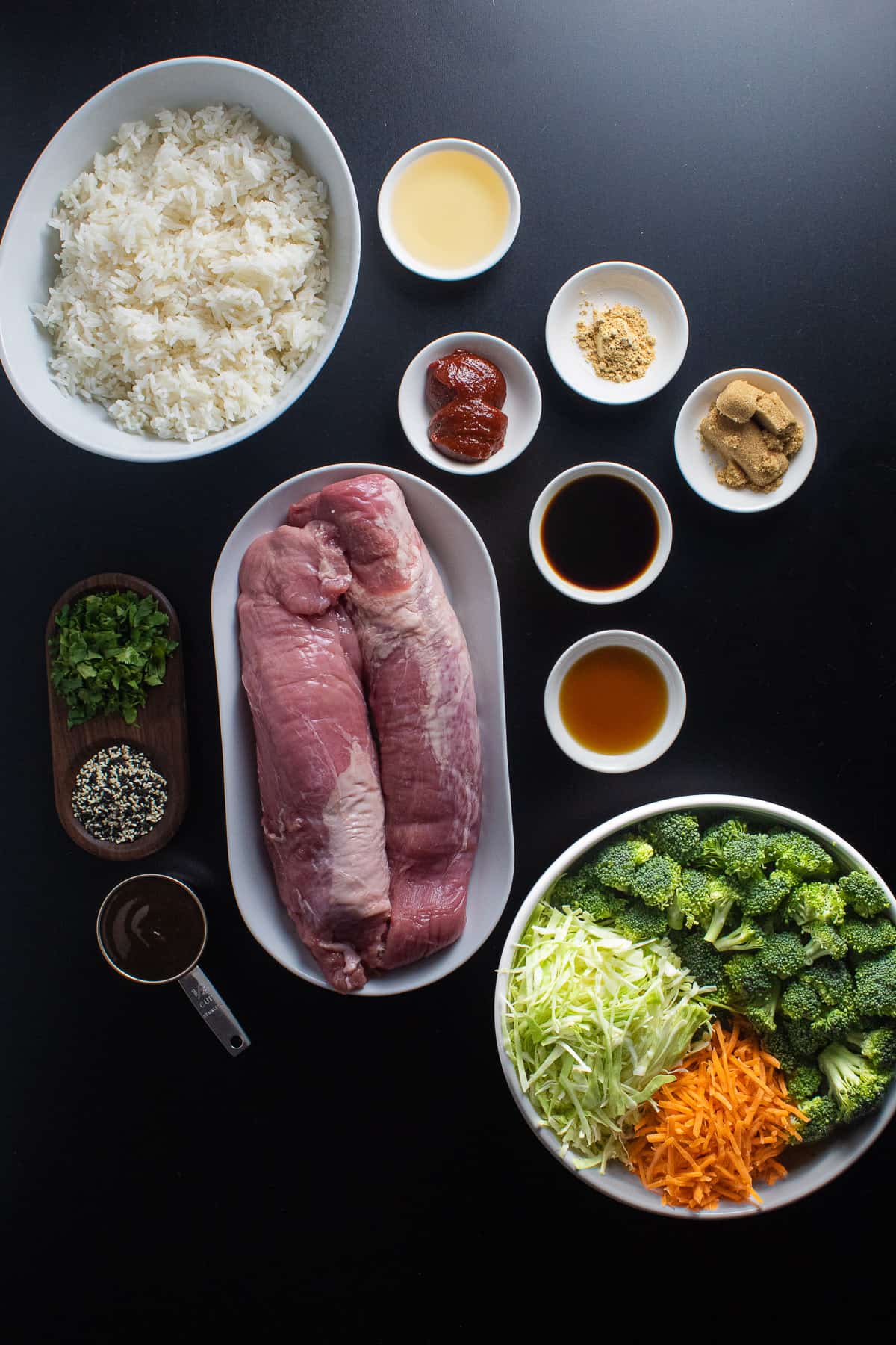 Ingredients for the hoising pork and gochujang sauce are arranged on a black surface.