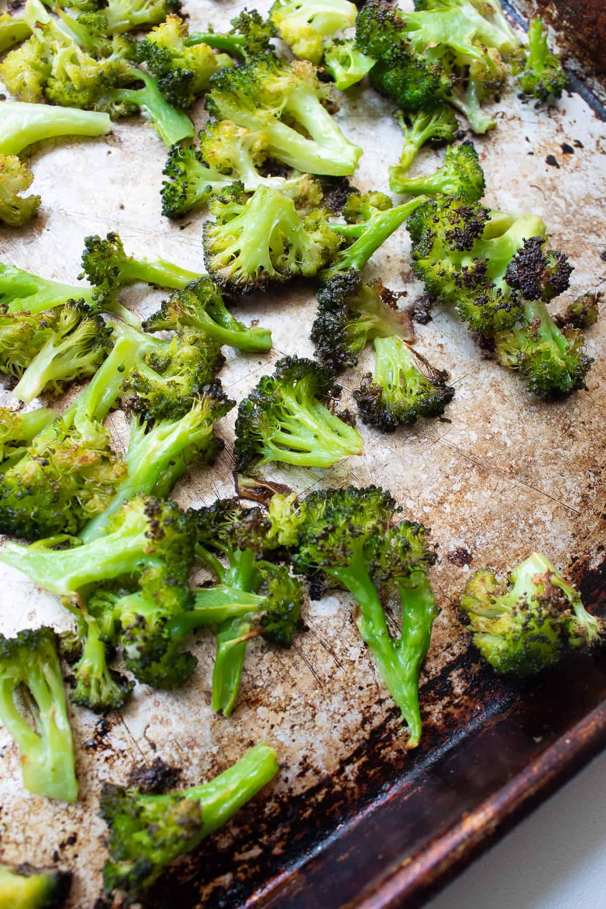 Charred broccoli on a sheet pan after roasting.