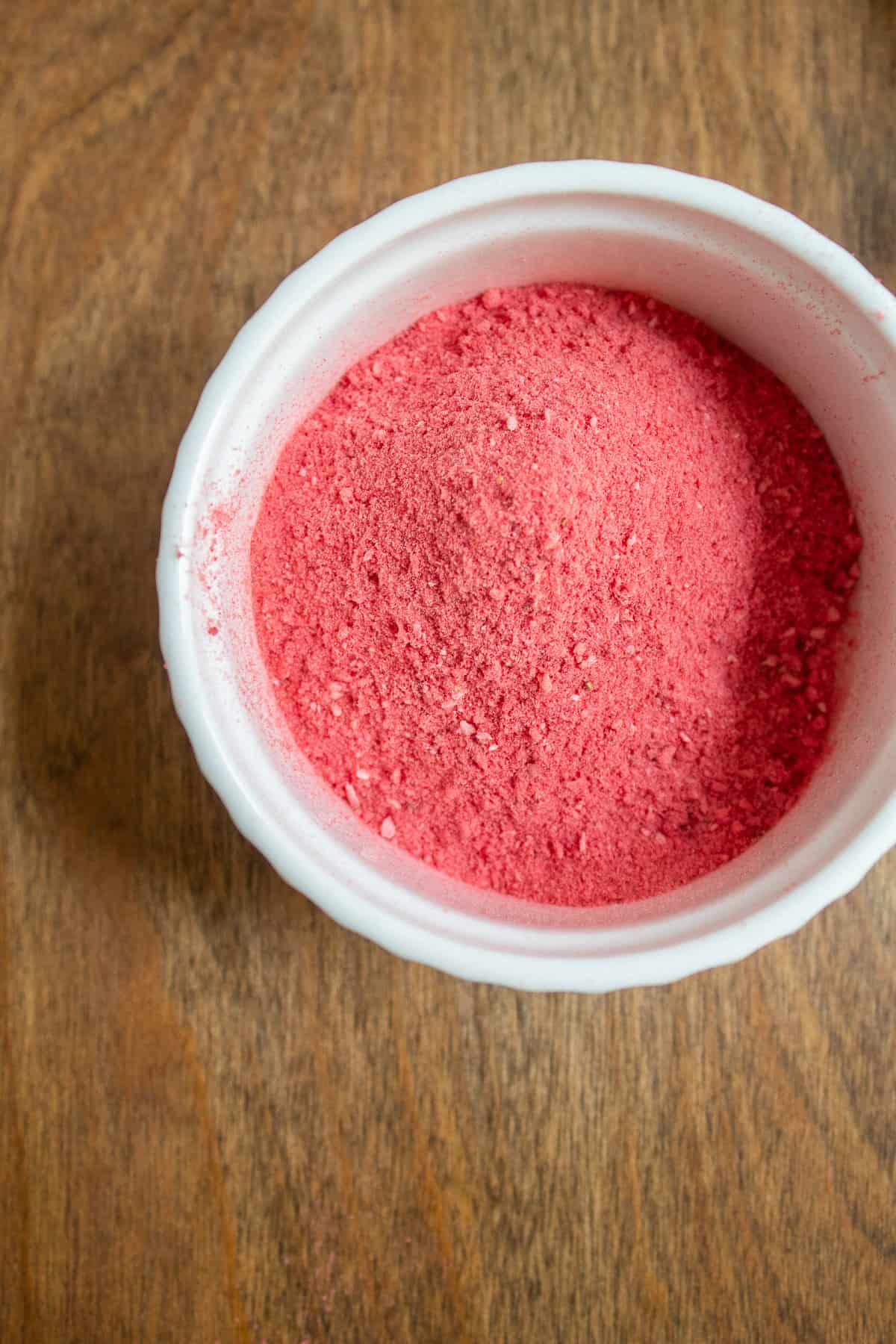 Crushed freeze-dried strawberry powder in a small white bowl.