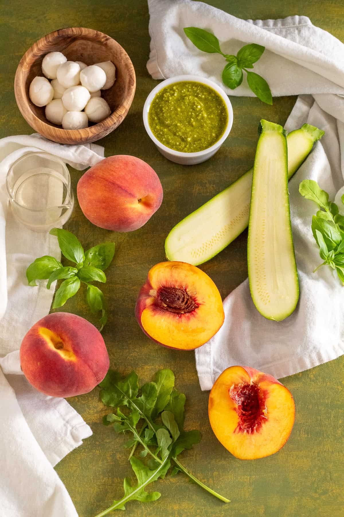 Ingredients for the salad are displayed on a green surface.