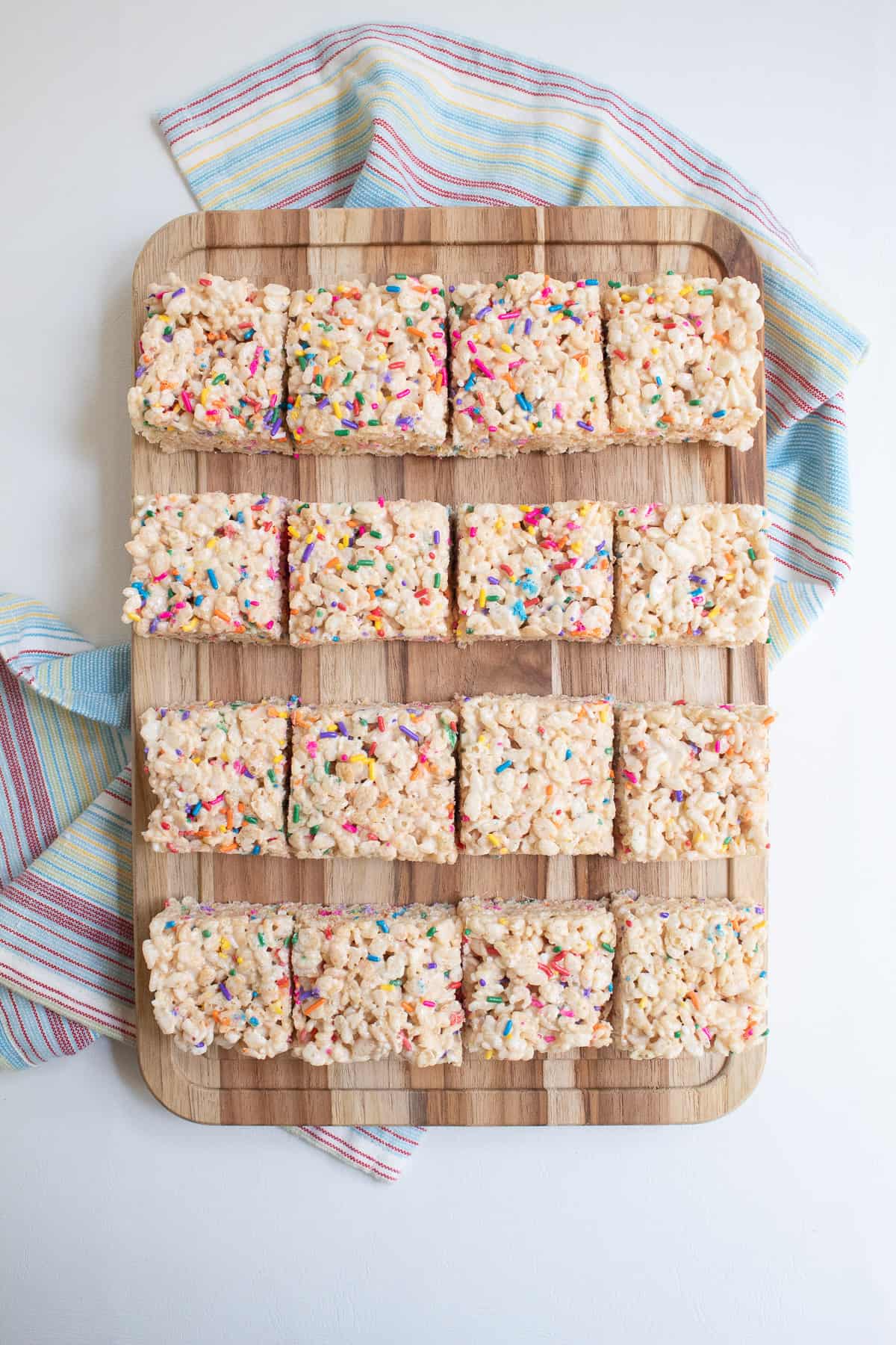 The treats are cut into 16 squares and displayed on a wooden cutting board.