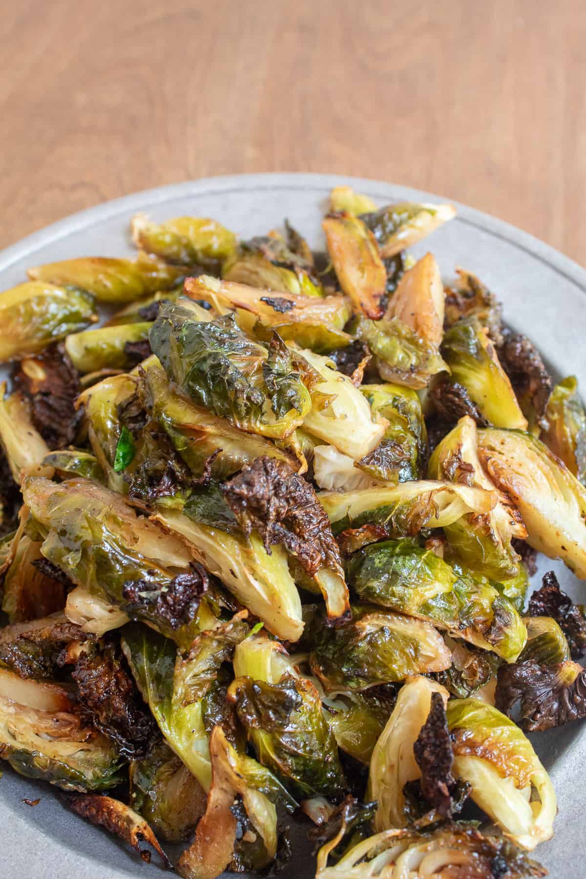 The finished brussel sprouts are golden and shiny and some of the pieces are caramelized and crisp looking.