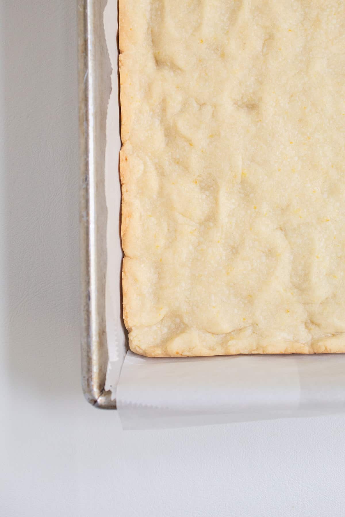The light golden color at the edges of the parbaked shortbread crust.