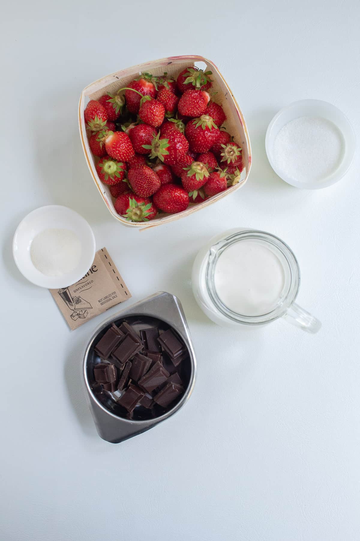 The ingredients for the mousse recipe are arranged on a white surface.