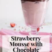 A footed serving glass is filled with a layer of pink mousse, a layer of dark chocolate, and a garnish of whipped cream and a sliced strawberry. A box with the words "strawberry mousse with chocolate ganache" and "Plan. Eat. Post. Repeat." is at the bottom of the image.