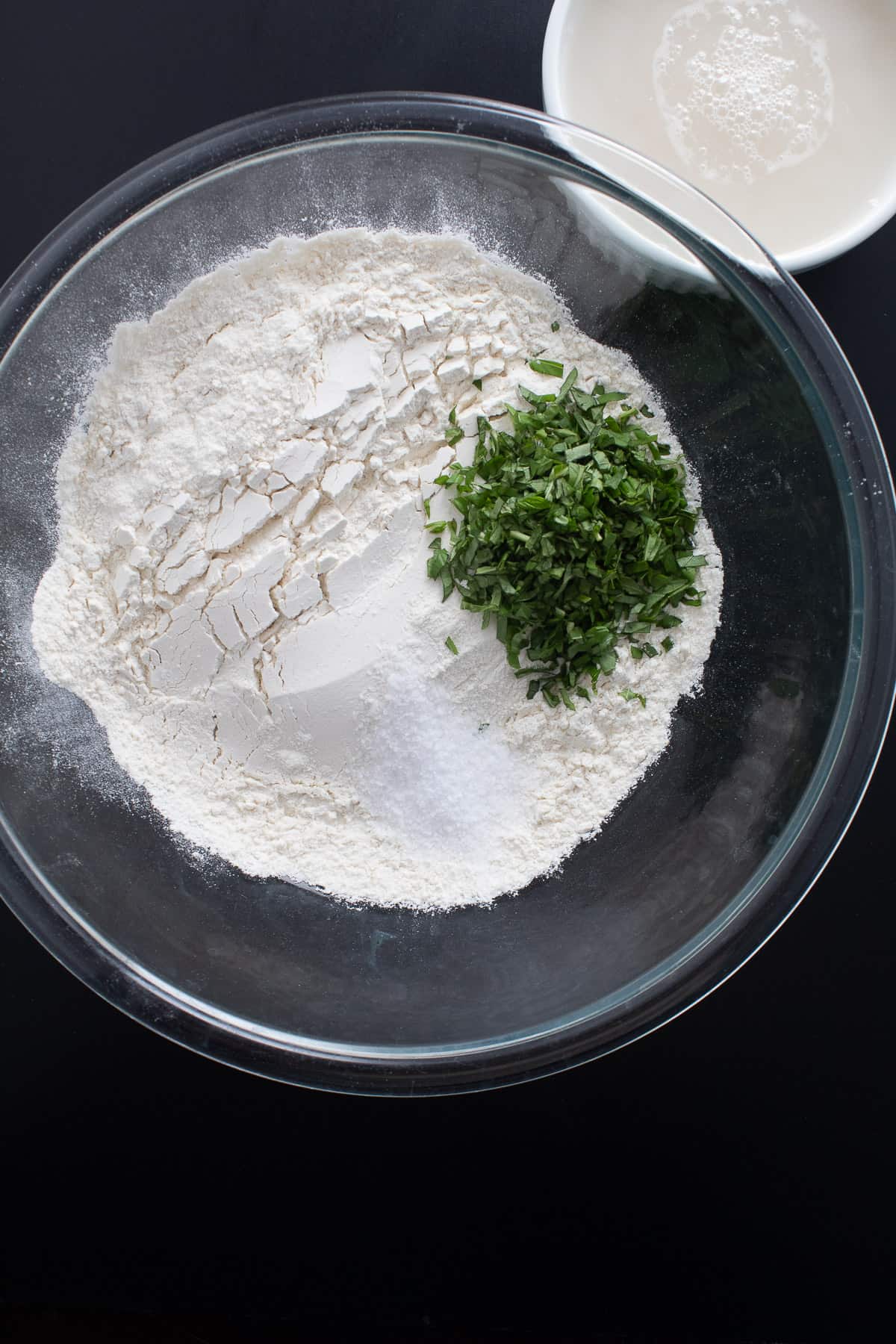 The dry ingredients and the chopped basil in a large glass bowl.