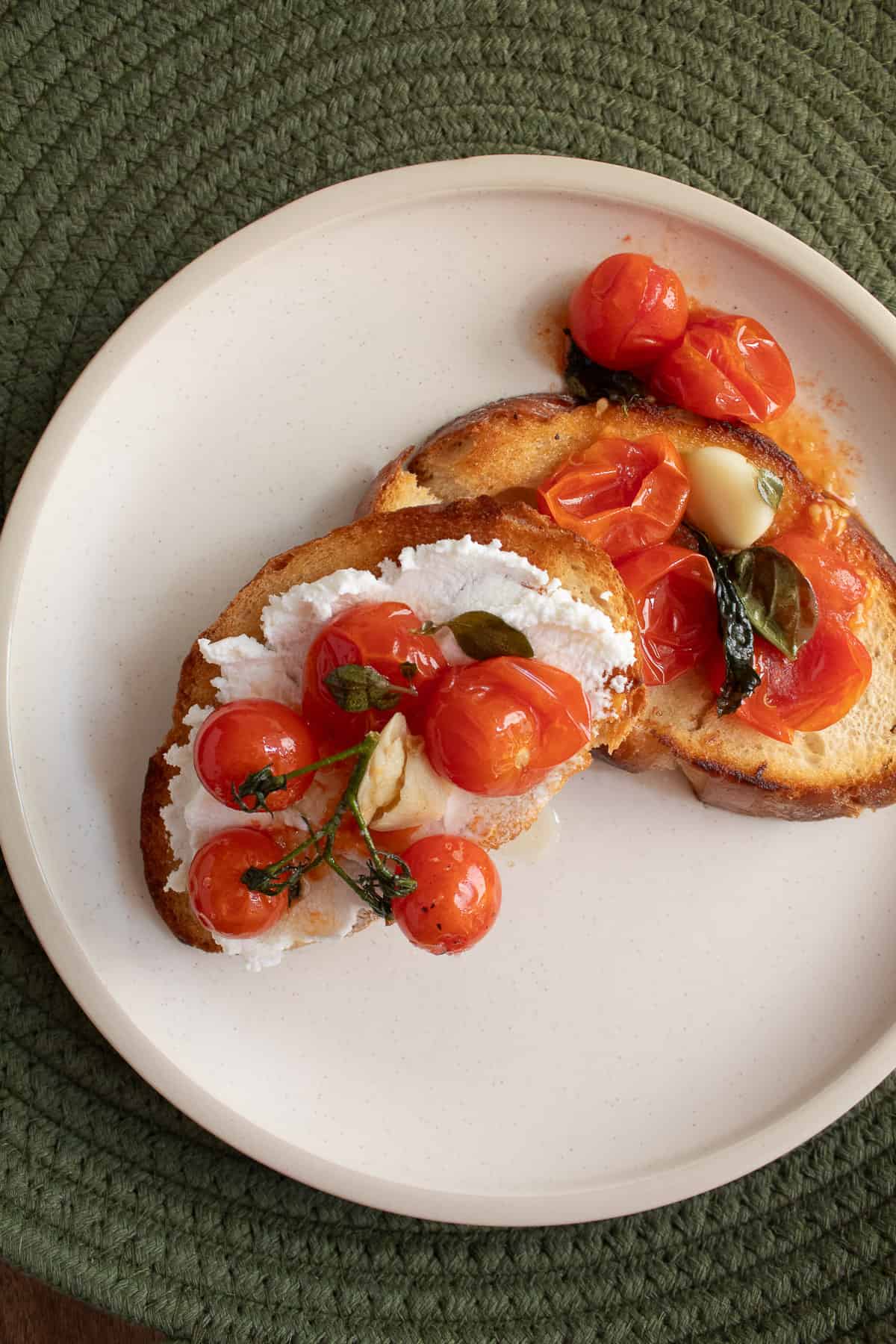 Tomato confit bruschetta on a white plate.