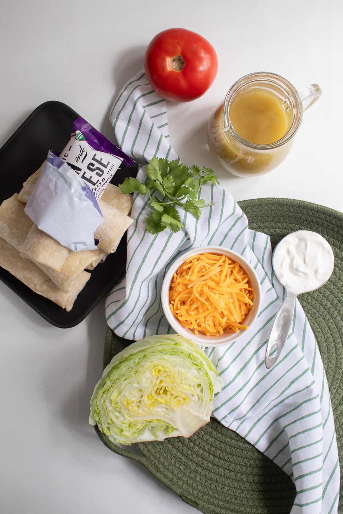 The ingredients for the burrito casserole are displayed on a green and white surface.
