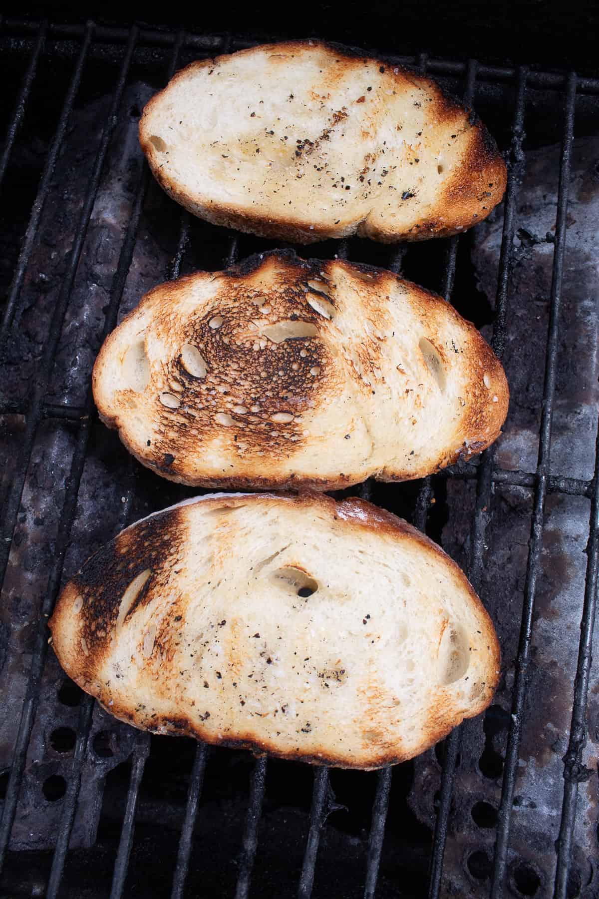 Seasoned bread is grilled over the grates and lightly charred in some spots.