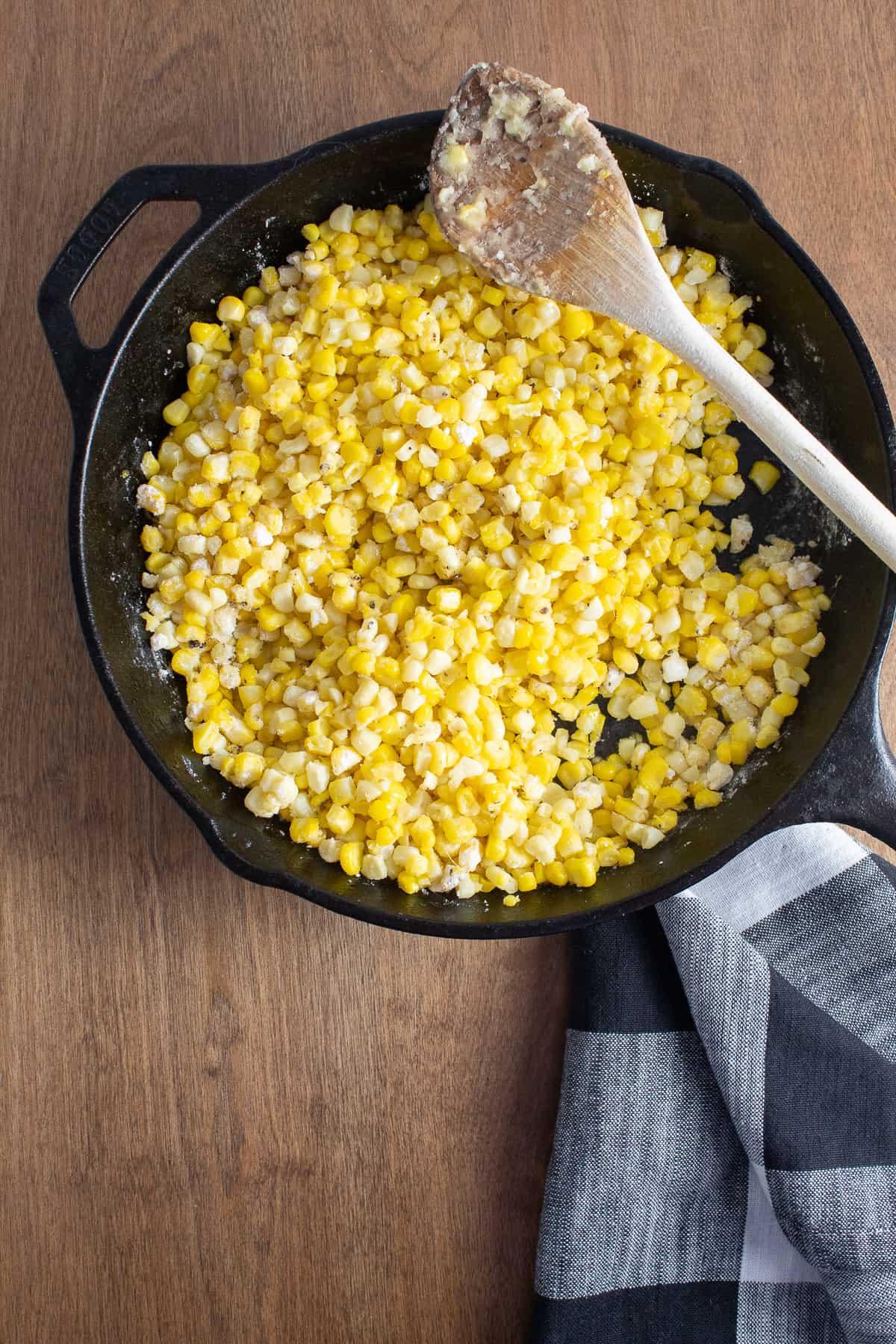 The corn kernels are coated with the cooked flour and butter mixture.