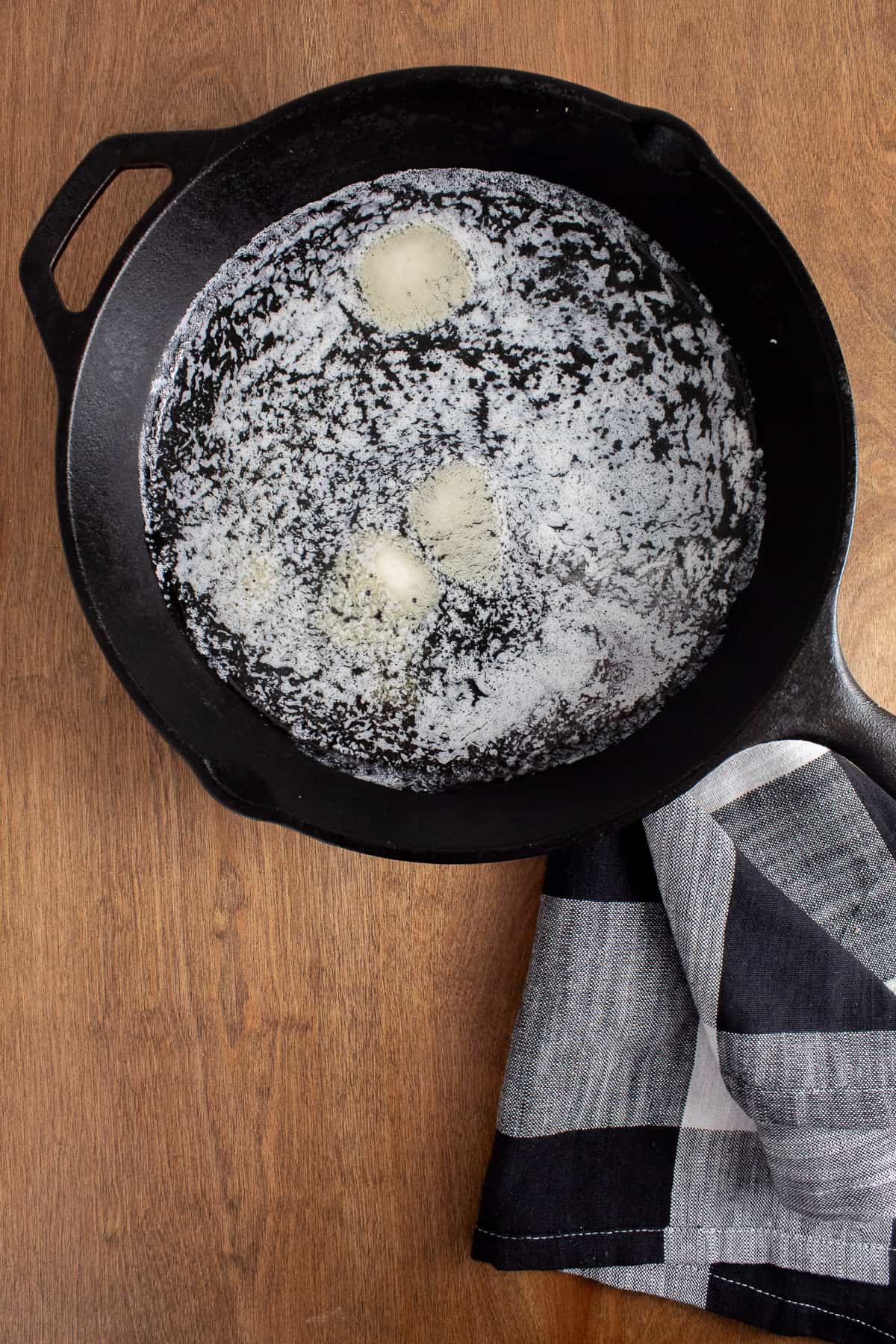 Melted butter in the bottom of a cast iron skillet.