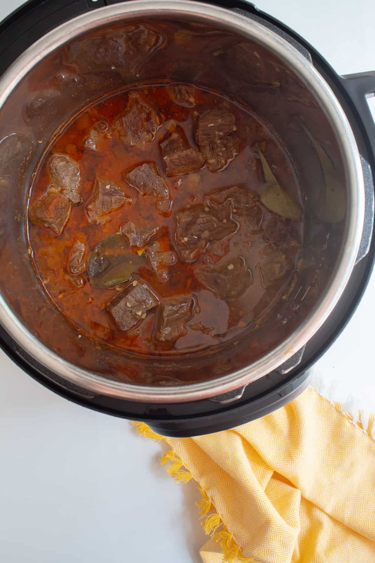 The beef mixture after cooking is a bright red color with an oil layer sitting on top.