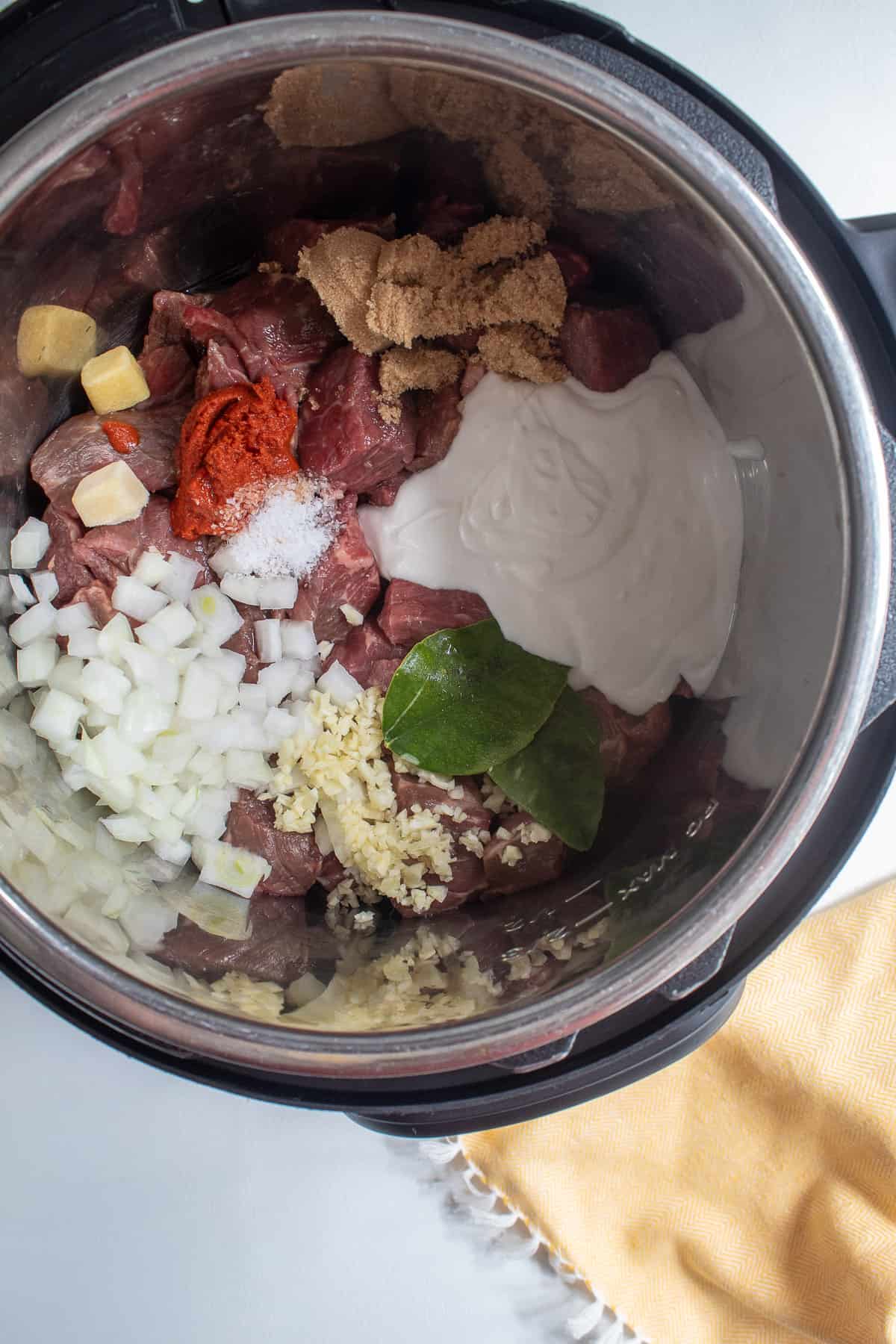 The ingredients for the beef are loaded into the Instant Pot.