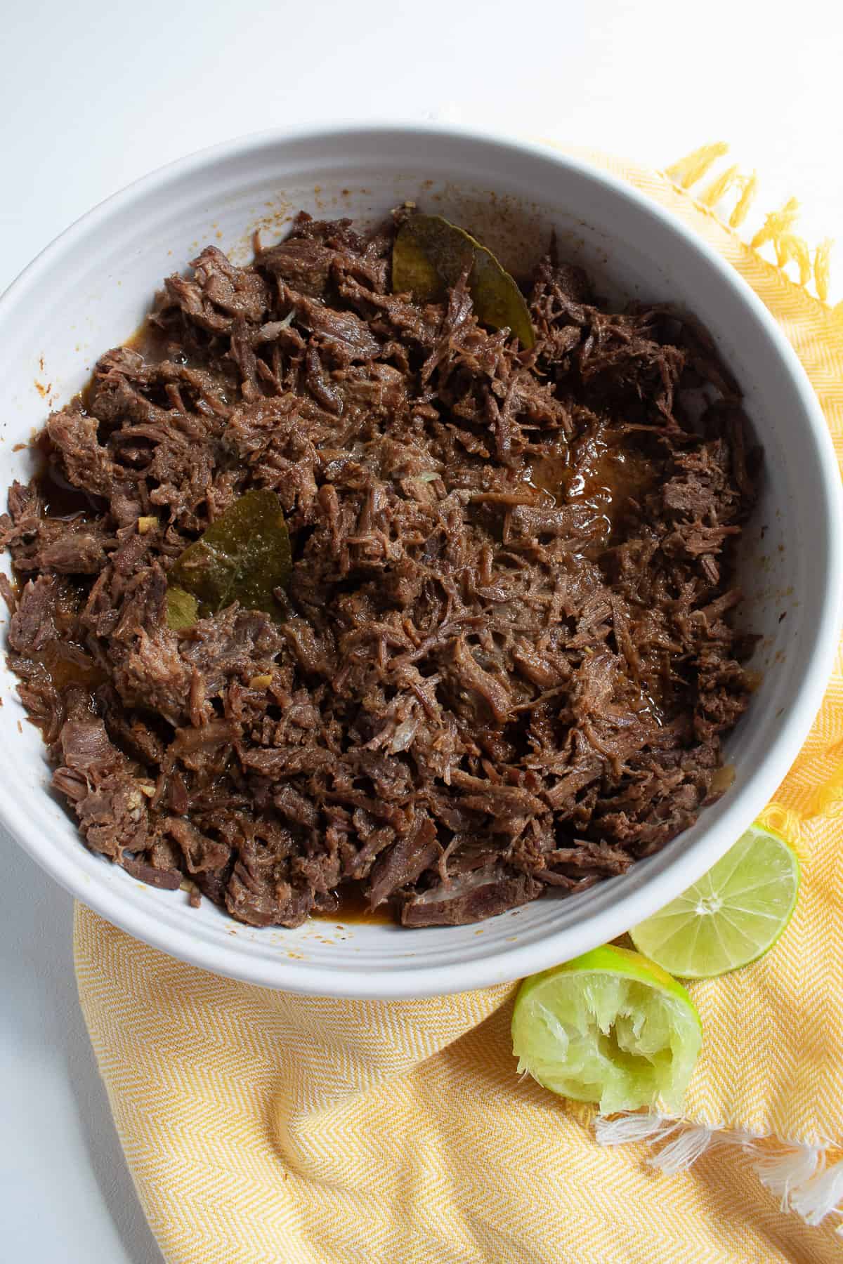 The shredded beef is coated with the finished sauce in a white bowl.