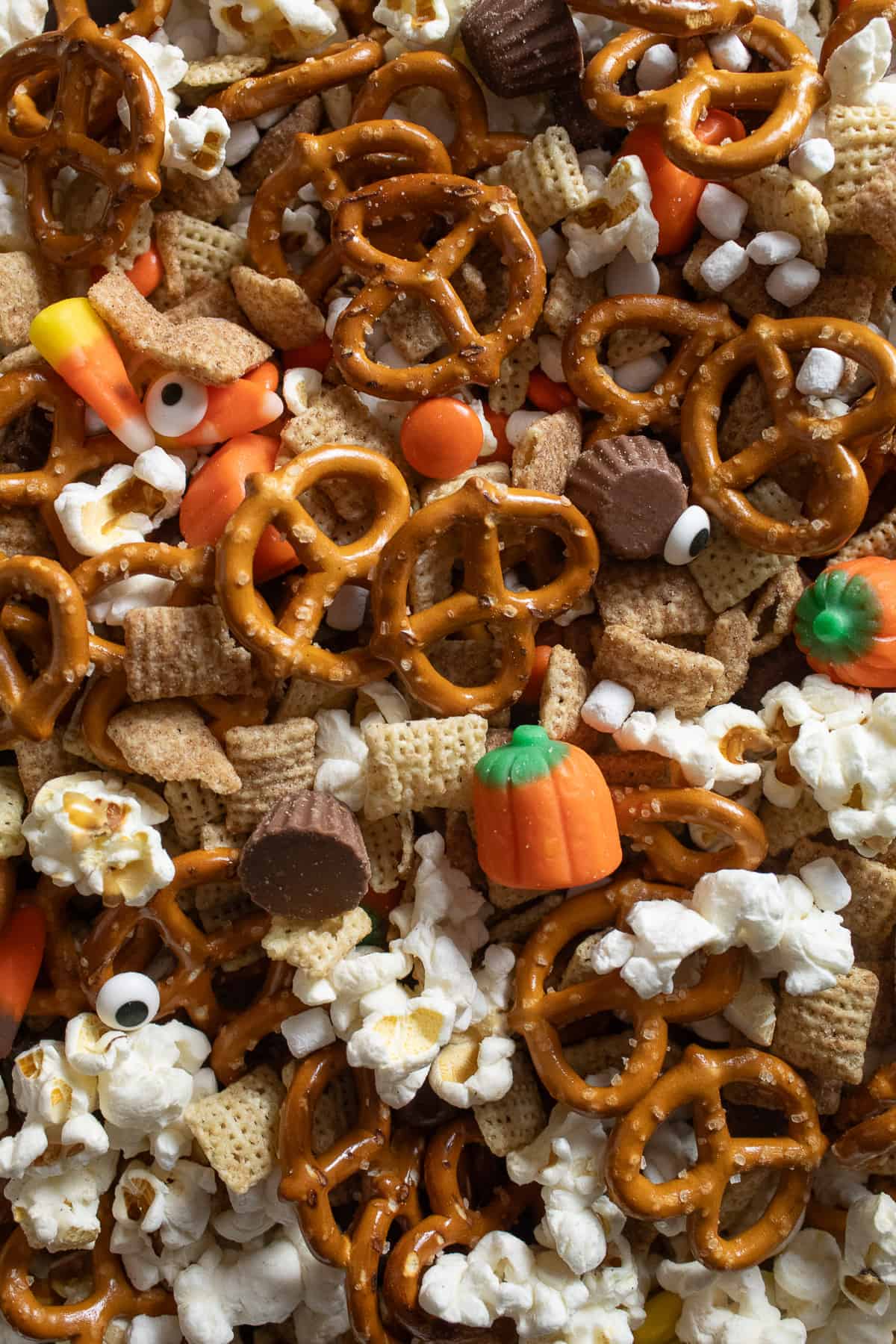 A detail image shows all of the ingredients in the snack mix, including candy pumpkins, candy eyes, pretzels and more.