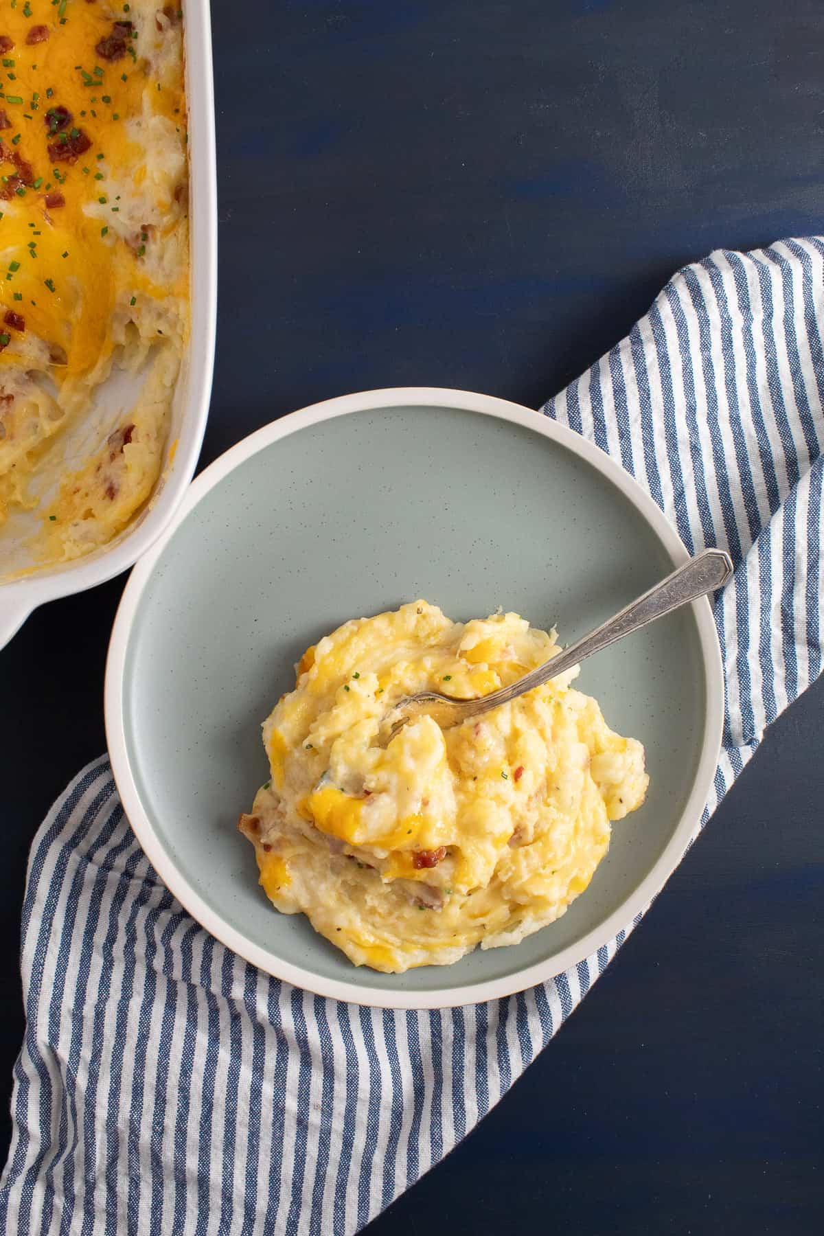 A serving of the mashed potato casserole sits on a light blue plate.