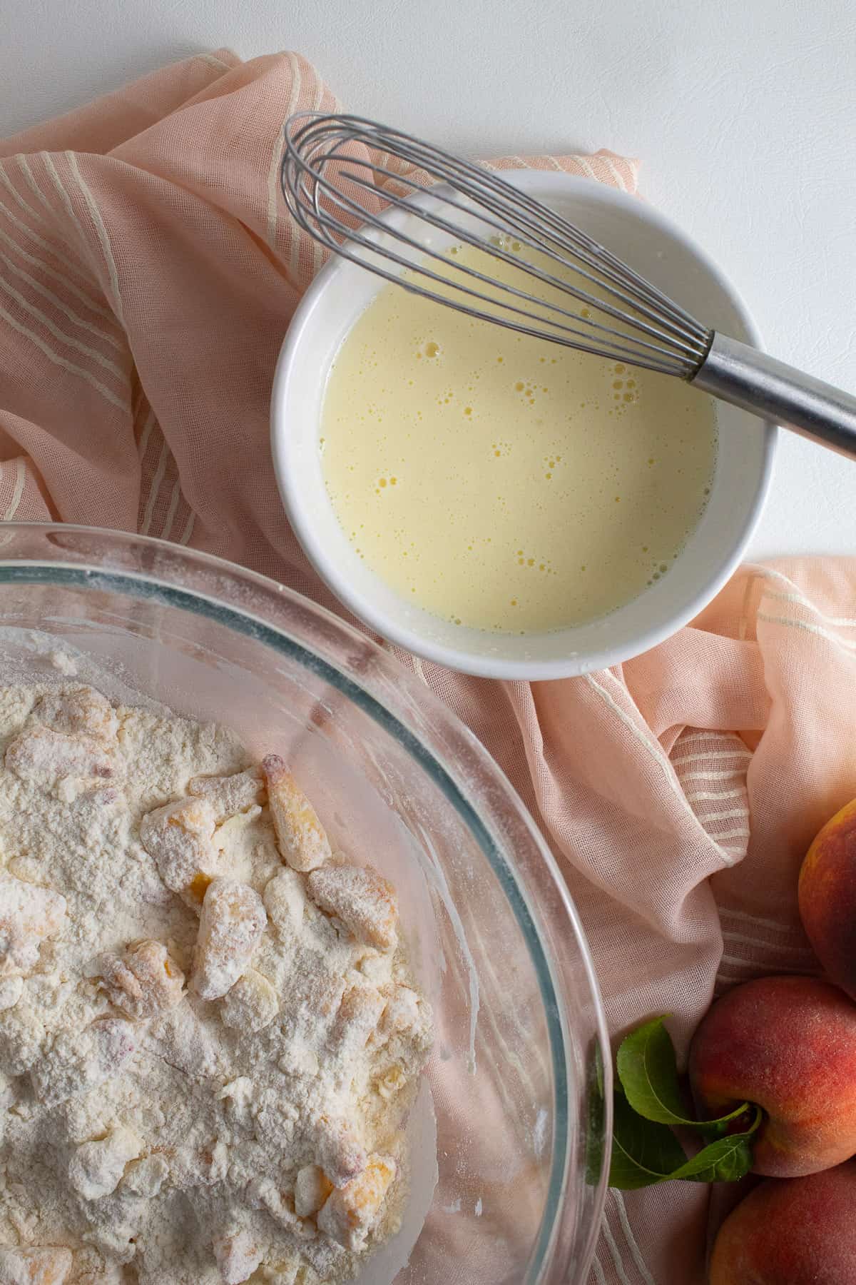 The wet ingredients are whisked together to a pale yellow mixture in a small white bowl.