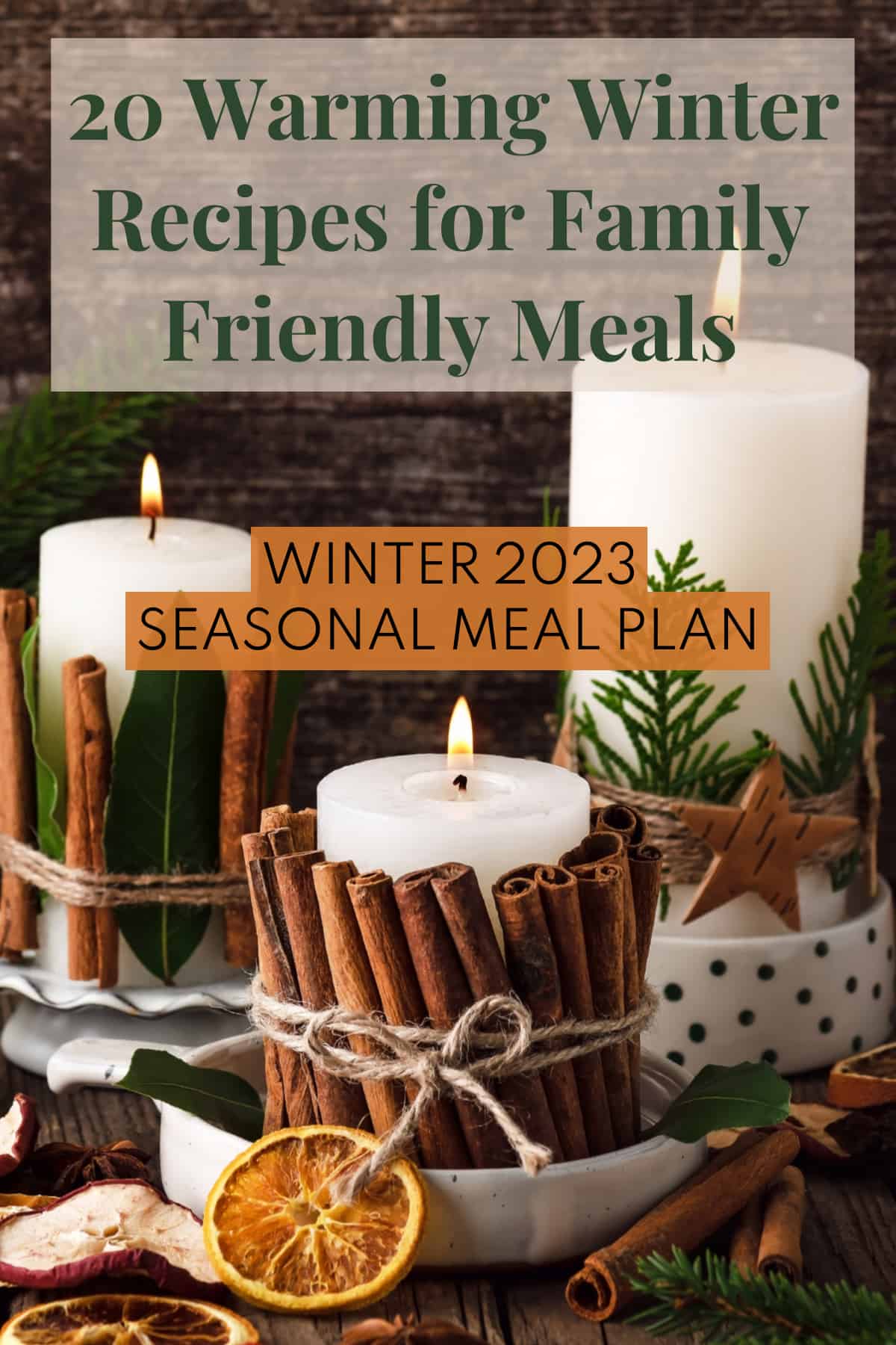 Candles wrapped in cinnamon sticks, bay leaves, and evergreen stems sit on a wooden surface. The words, "20 warming winter recipes for family friendly meals" and "winter 2023 seasonal meal plan" are in two boxes overlaid on the image.