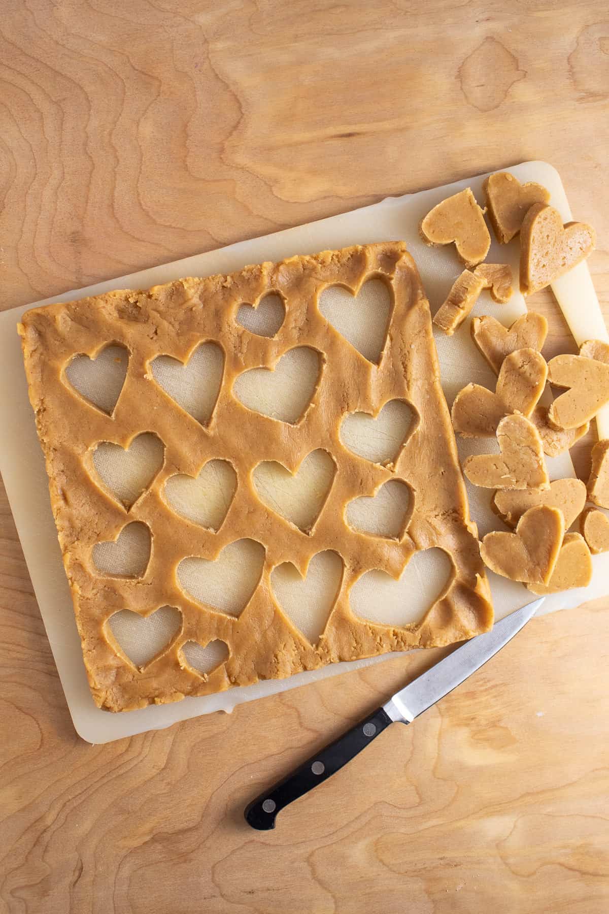 A paring knife is used to cut heart shapes out of the chilled layer of dough.