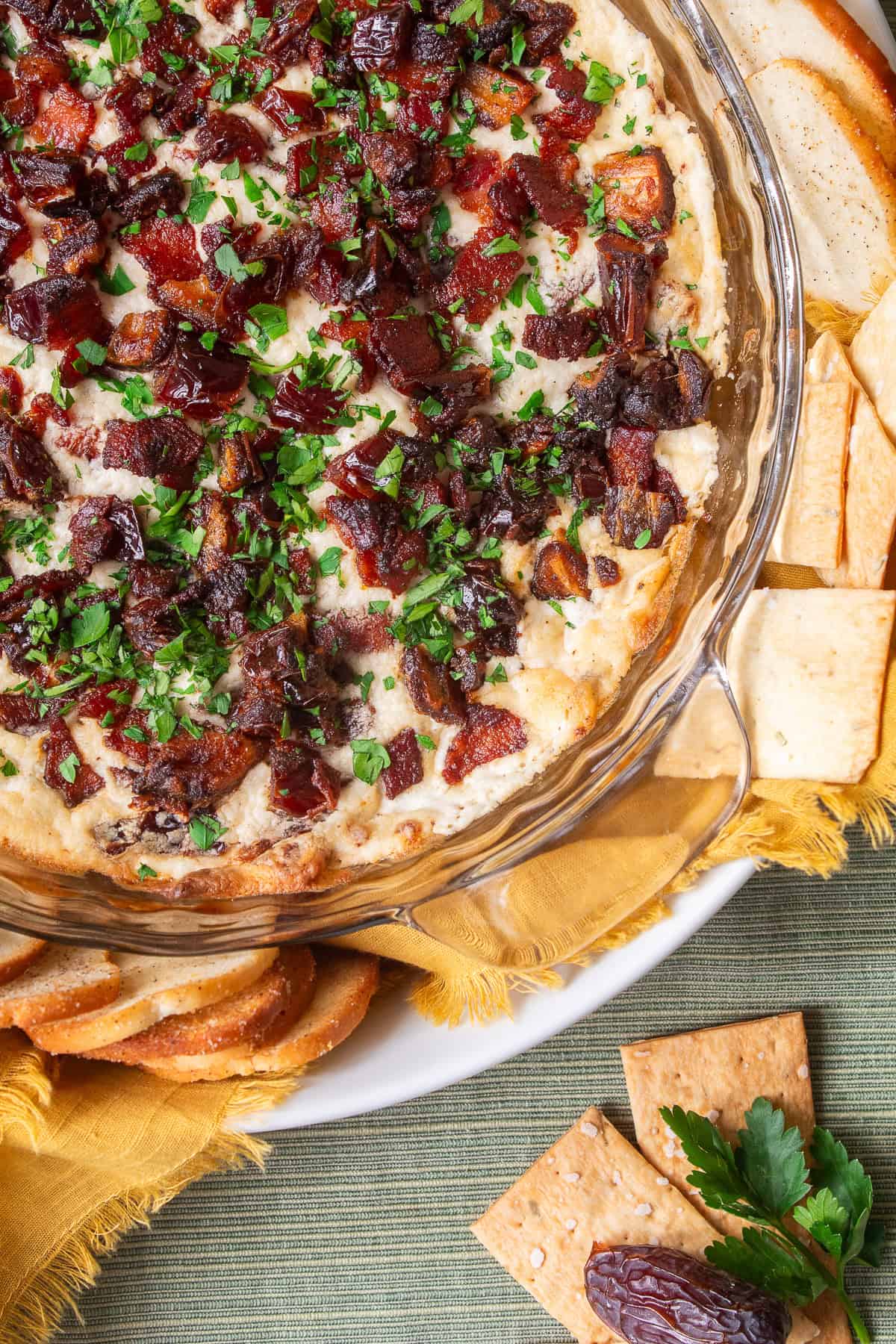 A detail image of the baked dip shows the caramelized dates, crisp bacon, and fresh parsley.