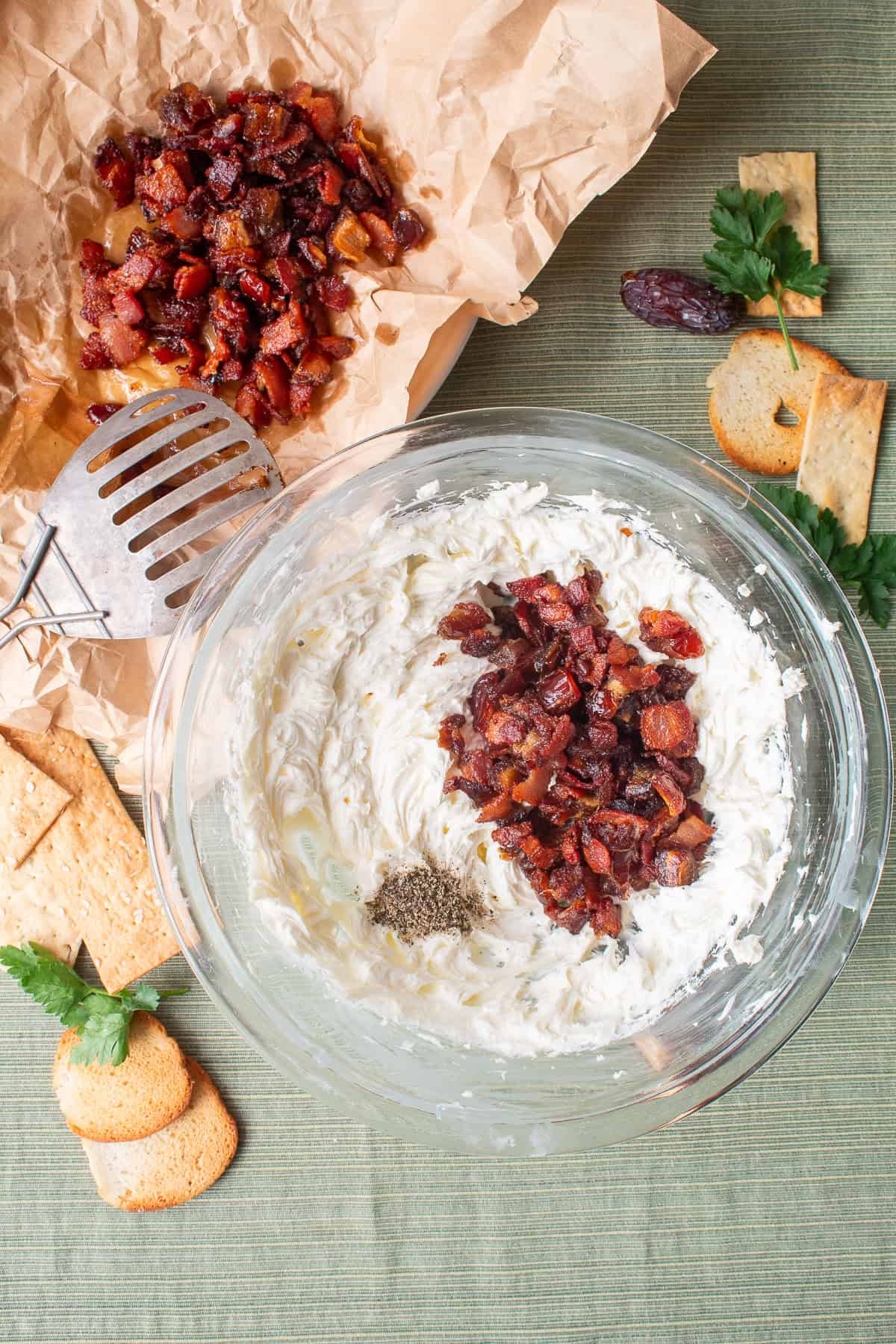 Half of the date and bacon mixture and the black pepper are stirred into the whipped cheeses.