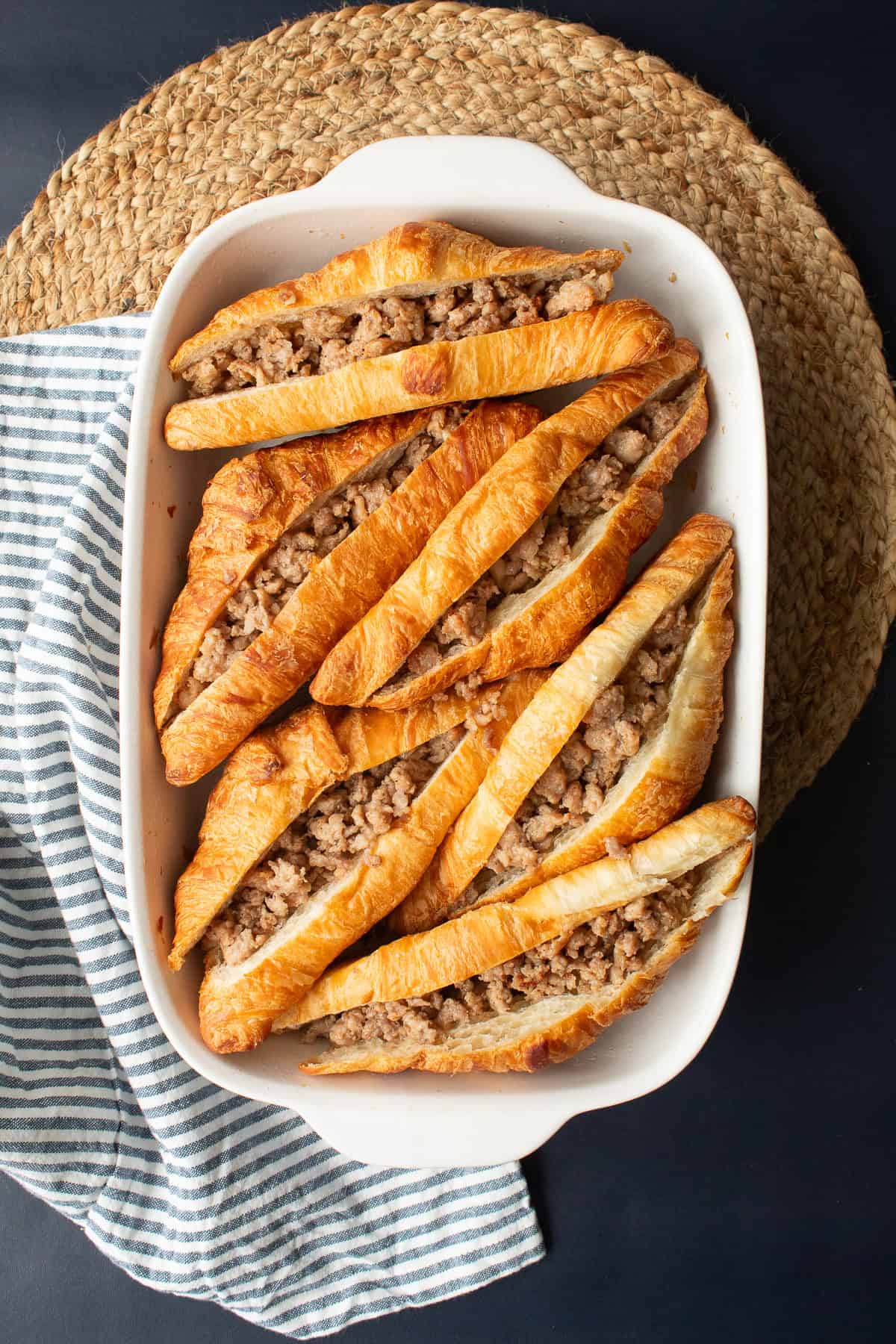The croissants are filled with cooked sausage.