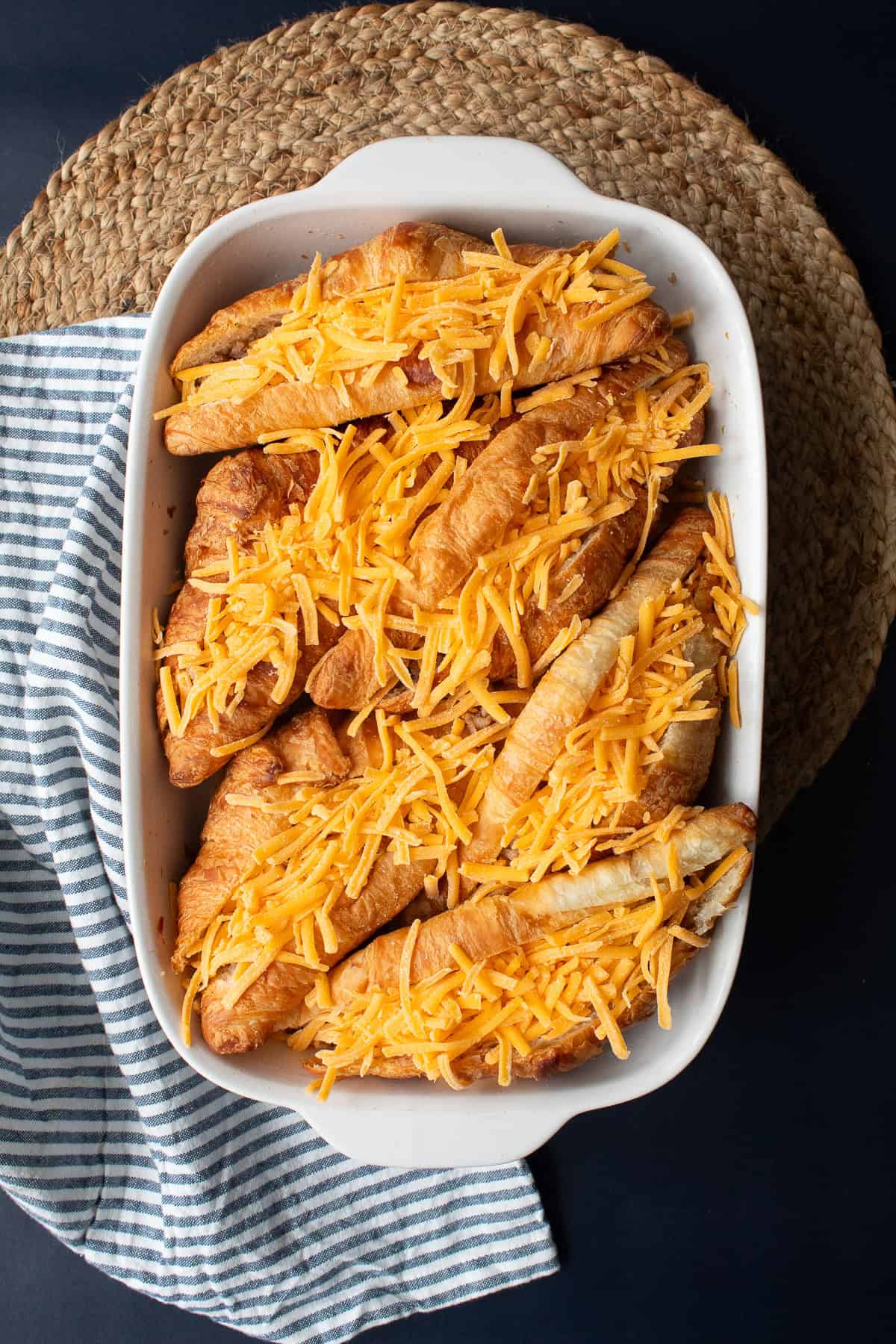 Shredded sharp cheddar is sprinkled inside each sliced croissant to top the sausage filling.