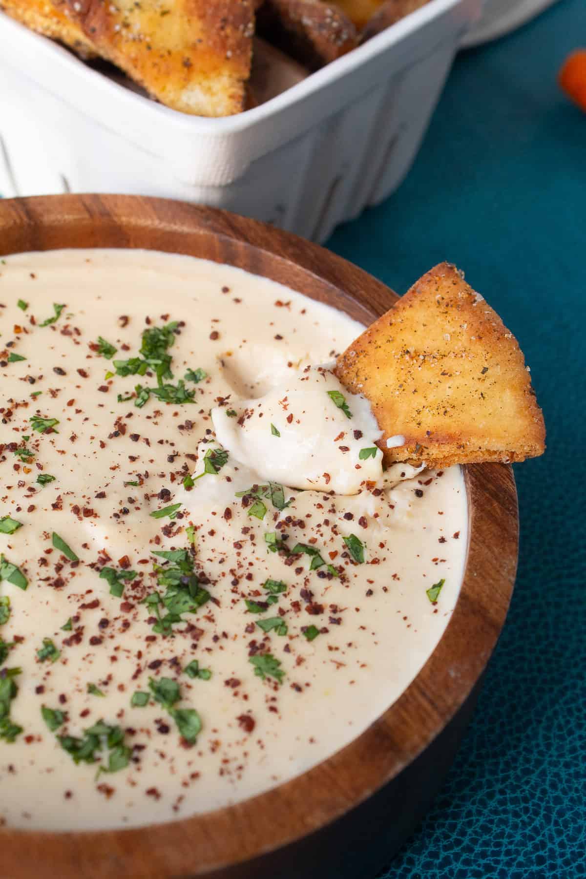 A detail image of the lentil hummus shows a creamy texture and the garnish of parsley and sumac.